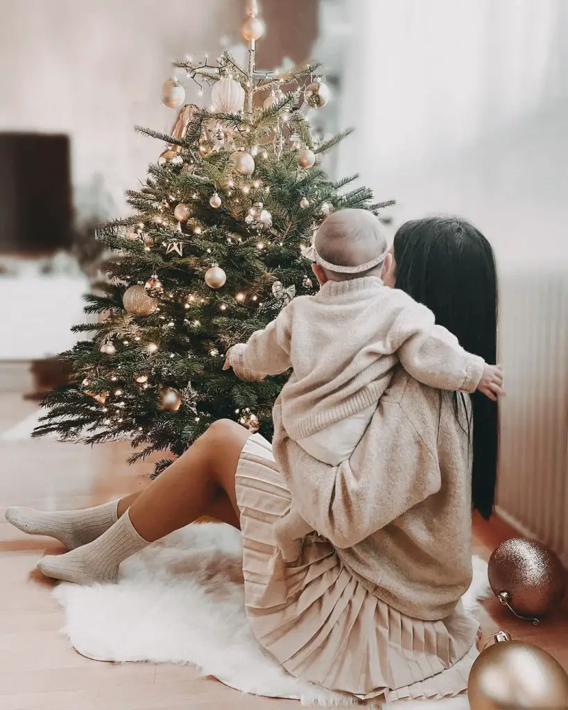 Mama and baby by the christmas tree